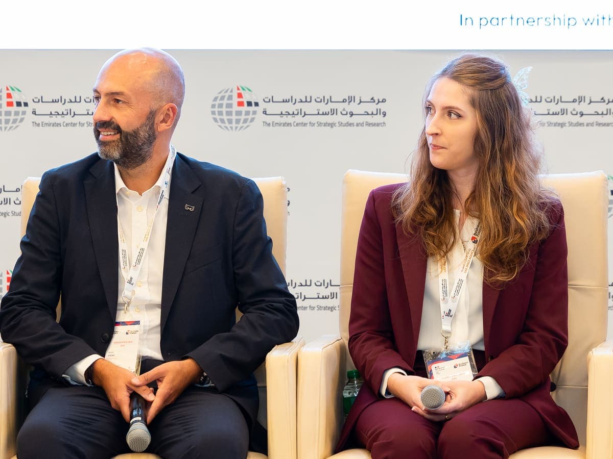 Dr. Justine Sarrau listening to a fellow panellist on stage